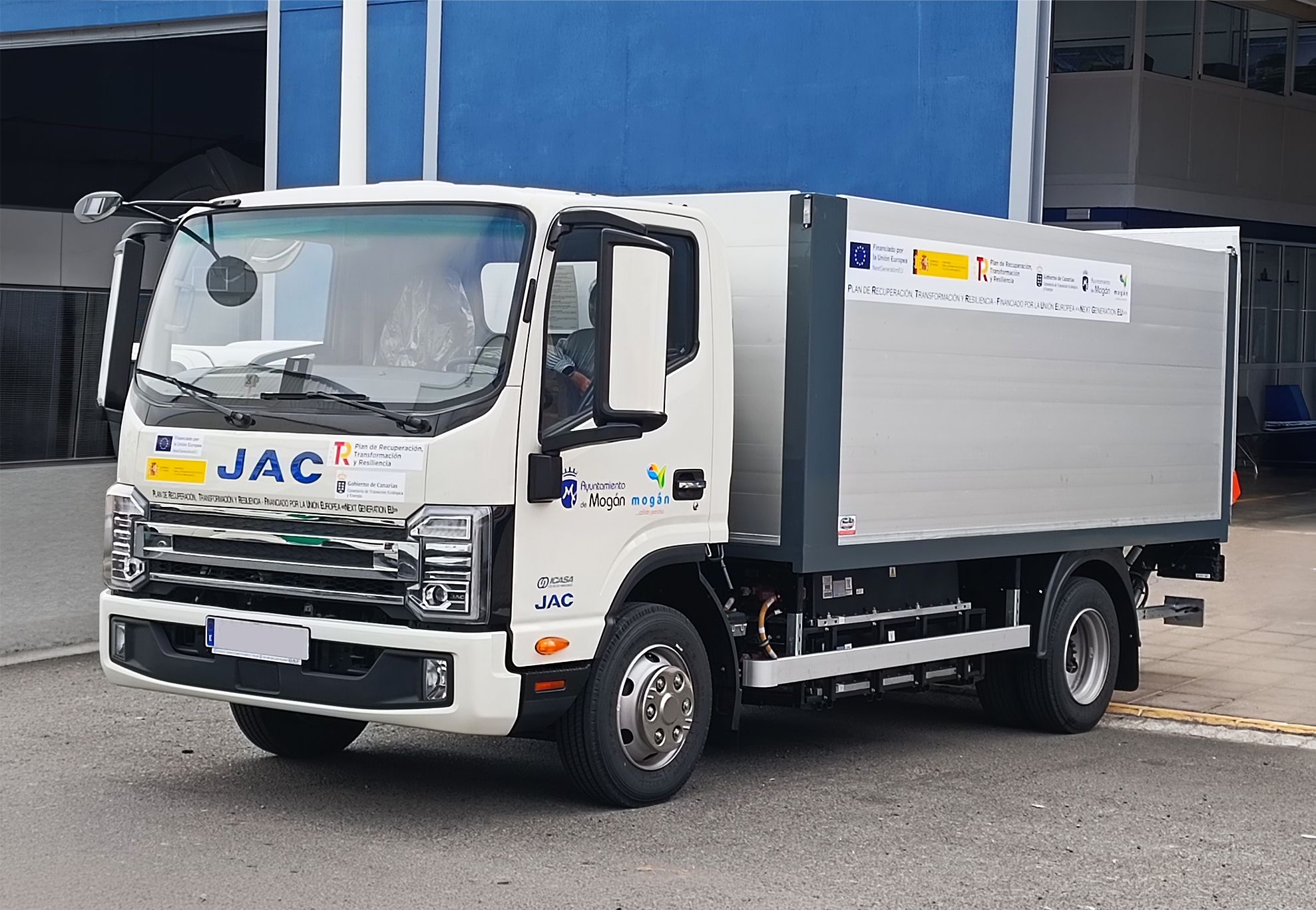 Camión eléctrico JAC de 7,5 toneladas blanco con caja cerrada rotulada, suministro por WARSA para servicios municipales.